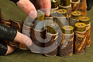 Hands of shooter fill a bandolier of ammo