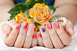 Hands with short manicured nails colored with pink and red nail polish