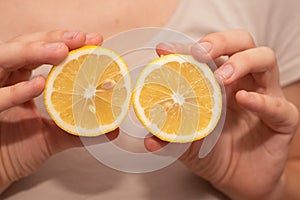 Hands Showcasing Half a Lemons. A person& x27;s fingers displaying a bright lemon half