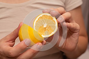 Hands Showcasing Half a Lemons. A person& x27;s fingers displaying a bright lemon half