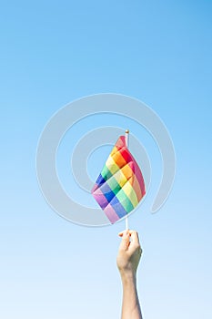 Hands showing LGBTQ Rainbow flag on nature background. Support Lesbian, Gay, Bisexual, Transgender and Queer community and Pride