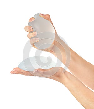 Hands showing and squeezing soft breast implant. , clipping path.