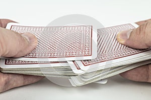 Hands shuffling playing cards on white background