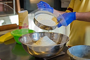 Hands Sift flour in bowl
