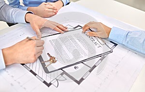 Hands signing property purchase contract at office