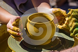 hands of the skilled master Potter and children's hands, training of the kid to production of pottery on a Potter's wheel