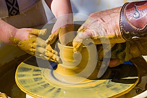 hands of the skilled master Potter and childrens hands, training of the kid to production of pottery on a Potters wheel