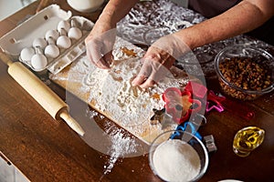 Hands of skillful cook mixing dough ingredients