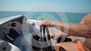 Hands of the skipper at the helm control