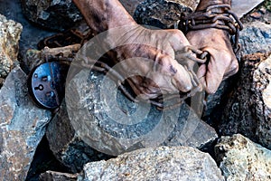 The hands of a slave in an attempt to release. The symbol of slave labor. Hands in chains