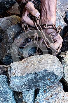 The hands of a slave in an attempt to release. The symbol of slave labor. Hands in chains