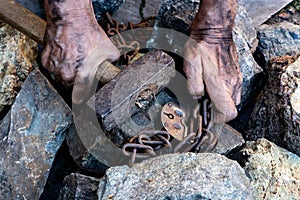 The hands of a slave in an attempt to release. The symbol of slave labor. Hands in chains