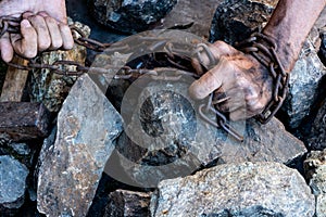 The hands of a slave in an attempt to release. The symbol of slave labor. Hands in chains