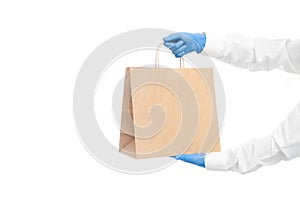 Hands in sleeves in sterile gloves of courier for safe delivery of food in eco-friendly package.