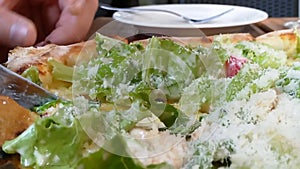 Hands slice pizza salad
