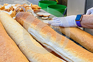 Hands Slicing Loaves of French Bread to Feed the Multitudes