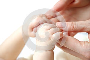 Hands of a small newborn baby hold on to fingers