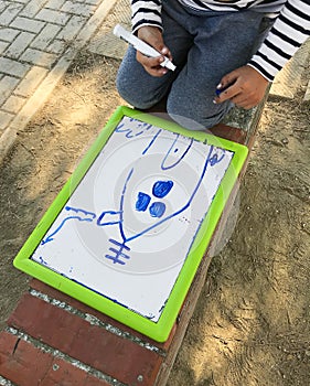 Hands of small student drawing on whiteboards