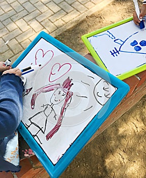 Hands of small student drawing on whiteboards