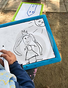 Hands of small student drawing on whiteboards