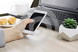 hands with smartphone on a bsckground of working place with laptop,succulent and coffee cup