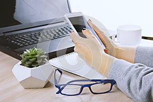 hands with smartphone on a bsckground of working place with laptop,succulent and coffee cup