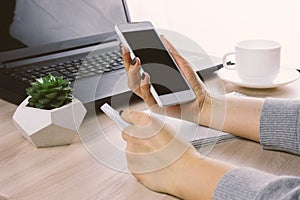 Hands with smartphone on a bsckground of working place with laptop,succulent and coffee cup