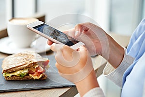 Hands with smartphone photographing food