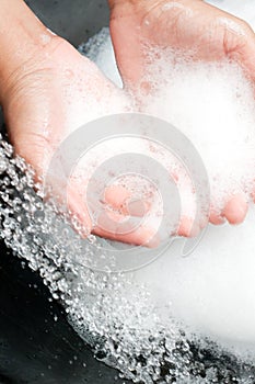 Hands with soap under running water