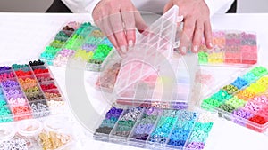 Hands sort through wide selection of colorful crafting beads