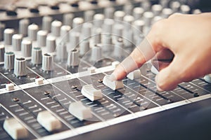 Hands of sound engineer working on recording studio mixer. Expert adjusting the volume of a voice, mixing console with mixer board