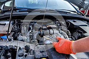 Hands with spanners and car engine close up. Car service concept