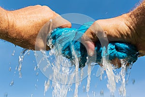 Hands squeeze cloth.