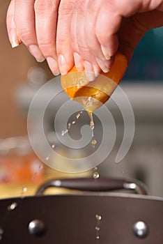 Hands squeeze juice from fresh and juicy orange
