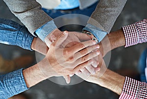 Hands stacked and piled to show team unity, strength and motivation among business men, colleagues and coworkers. Above