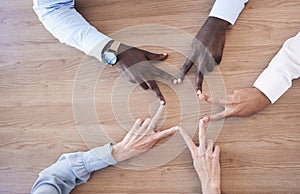 Hands, star and collaboration overhead with a business team in the office sitting at a boardroom table. Hand sign, shape