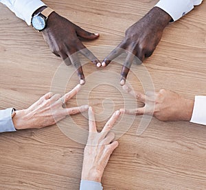 Hands, star and teamwork overhead with a business team in the office sitting at a boardroom table. Hand sign, shape or