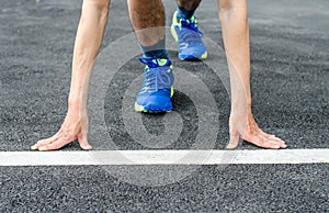 Hands on starting line , Male runner is about to start to run