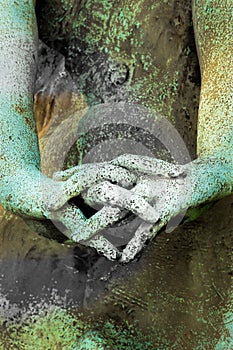 Hands of a statue with fingers crossed