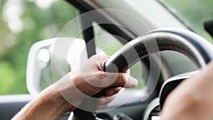 Hands on the steering wheel of the car - a view from the car interior. Driving on the highway, traveling