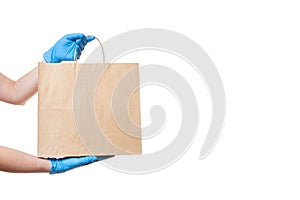 Hands in sterile gloves of a courier for the safe delivery of food.