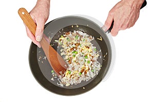 Hands stirring fried rice