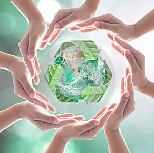 Hands surrounding green planet protected by recycle sign leaf on blurred bokeh photo