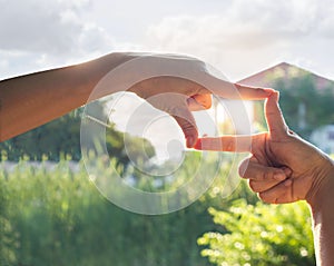 Hands symbol in front of house in sunshine nature background