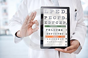 Hands, tablet screen and snellen chart in hospital for vision examination in clinic. Healthcare, ok gesture or woman