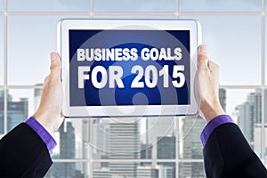 Hands with tablet showing business goals for 2015