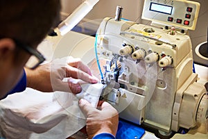 Hands of tailor and sewing machine