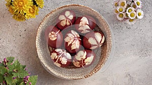 Hands taking a basket full of natural brown Easter eggs dyed with onion peels from a table