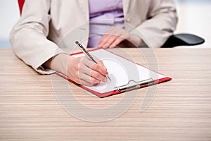 The hands taking notes in the pad