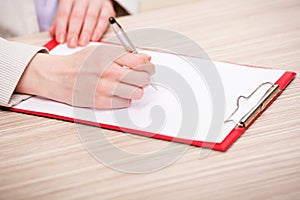 The hands taking notes in the pad